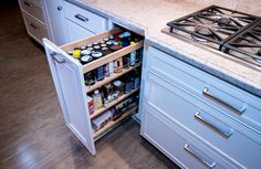 an open cabinet in the middle of a kitchen