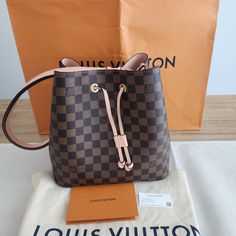 Authentic Louis Vuitton Damier Ebene Nono Is A Classic Bucket Style Shoulder Bag. Crafted In Louis Vuitton Damier Checkered Coated Canvas. Features A Sleek Shape, Colorful Leather Trim And A Matching Bonded Lining. Adjustable Strap Can Be Slung Over The Shoulder Or Lengthened For A Trendy Crossbody Carry. Brand New And Never Worn!! -10.2 X 10.2 X 6.9 Inches -Microfiber Lining -Gold-Colored Hardware -Drawstring -Metal Eyelets -Strap Drop: 13 Inches -Strap Drop Max: 22 Inches -Includes Original Ta Luxury Monogram Canvas Bucket Bag In Pouch Shape, Designer Travel Bucket Bag With Branded Hardware, Louis Vuitton Damier Ebene, Damier Ebene, Colored Leather, Leather Trim, Authentic Louis Vuitton, Louis Vuitton Damier, Leather Trims