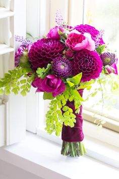 a bouquet of flowers sitting on top of a window sill