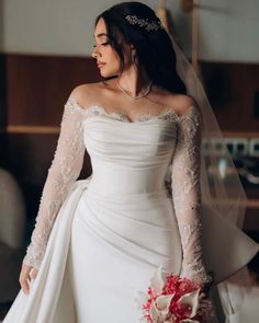 a woman in a wedding dress holding a bouquet and looking off to the side with her hand on her hip