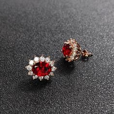 pair of red and white diamond earrings on black surface