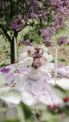 the table is set with flowers and candles