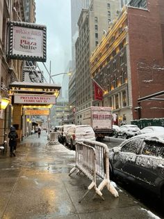 a city street filled with lots of traffic and covered in snow