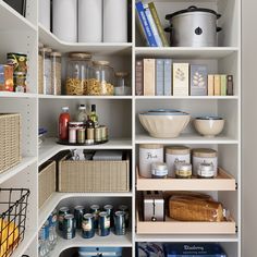 an organized pantry with white shelves and baskets