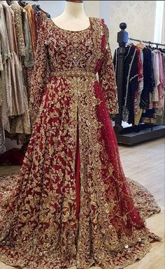 a red and gold wedding gown on display in a store with lots of other dresses