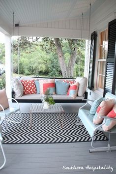 the porch is decorated with colorful pillows and furniture