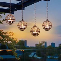 four lights hanging from the ceiling in front of a cityscape