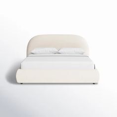 a bed with white sheets and pillows on it