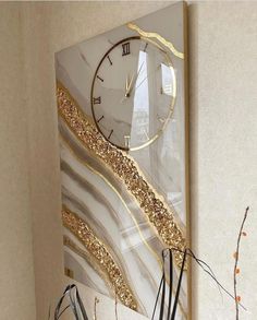 a clock mounted to the side of a wall next to vases filled with flowers