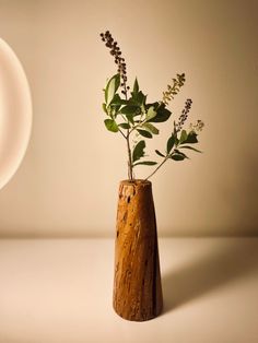 a wooden vase with some plants in it