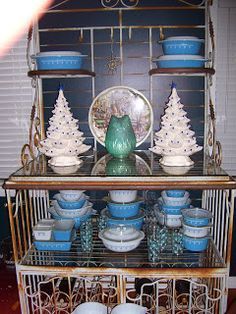 there is a shelf with dishes on it and christmas trees in the top tiers