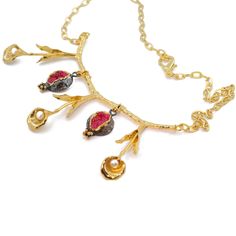 Introducing our exquisite pomegranate necklace, a true embodiment of elegance and allure. This captivating piece features a unique and enchanting design, with a peace flower at its center. The flower itself is adorned with natural pearls, adding a touch of grace and sophistication. The pomegranates, the focal point of this necklace, are embellished with striking ruby-colored quartz stones, which beautifully complement the overall design. Each pomegranate is meticulously crafted from high-quality brass, ensuring durability and longevity. To enhance its luxurious appeal, the necklace is beautifully coated with 24-carat gold, showcasing its intricate details with utmost brilliance. The pomegranates are further enhanced with a black rhodium plating, creating a striking contrast against the gol Peace Flower, Jewish Weddings, Pomegranate Necklace, Pomegranate Jewelry, Schmuck Gold, Fruit Necklace, Necklace Charms, Jewish Wedding, Elegant Gifts