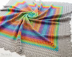 a multicolored crocheted blanket on top of a table