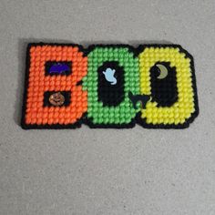 three beaded coasters with the word boo spelled out in different colors and shapes