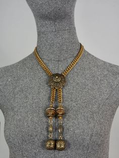 Features: - 100% Authentic JEAN PAUL GAULTIER. - Brutalist/ Tribal style necklace. - Toggle closure. - Signed JPG on reverse. - Comes with GAULTIER pouch. - Excellent vintage condition. Measurements: Pendant Drop: 7.48 inches (19 cms) Wearable Length: 16.92 inches (43 cm) **This necklace will be shipped via Priority Shipping with tracking number. Please convo me for any queries and additional photos. Thank you for visiting. Other Fees that buyers need to know: Please make sure you know and under Gold Vintage Charm Necklace For Festival, Gold Necklace With Vintage Charm For Festival, Elegant Gold Long Necklace For Festival, Antique Adjustable Necklaces For Festivals, Adjustable Antique Necklaces For Festivals, Antique Adjustable Necklace For Festivals, Gold Lariat Necklace With Adjustable Chain For Festival, Adjustable Bohemian Pendant Chain Necklace, Festival Metal Lariat Necklace