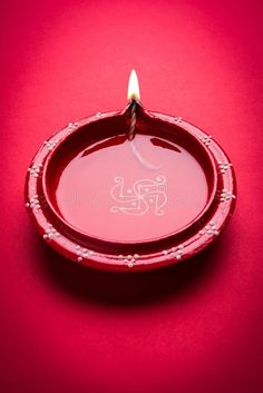 a candle is lit in a bowl on a red background royalty images and clippings