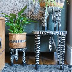 two planters sitting on top of small stools