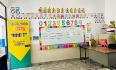 a classroom with desks, chairs and a large white board on the wall in front of it