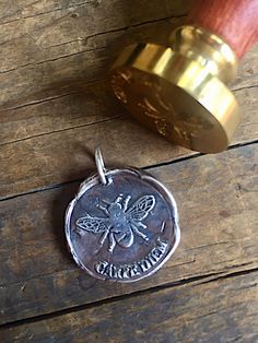 This silver Carpe Diem pendant is made from an impression of a wax seal stamp. Each seal is hand crafted of fine silver (.999) Sterling silver is (.925). Each one is unique as the process is done by hand and not a press. The one you order will look as close to the picture as possible but no two are exactly alike. This is a process of many steps involving forming, drying, firing, hand polishing, and adding the final patina. If you want the silver to be shiny, I can leave off the antique patina. Antique Silver Stamped Jewelry For Gift, Stamped Medallion Jewelry For Keepsake, Silver Hand Stamped Jewelry For Commemoration, Commemorative Hand Stamped Silver Jewelry, Stamped Round Pendant Jewelry For Commemoration, Silver Stamped Jewelry For Commemoration, Stamped Pendant Jewelry For Commemoration, Mixed Stone Necklace, Wax Seal Pendant