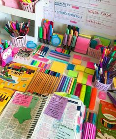 many different colored pens and pencils are on the table next to eachother