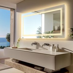 a bathroom with two sinks and a large window overlooking the ocean in front of it