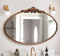 a bathroom sink with a mirror above it and two faucets on the wall