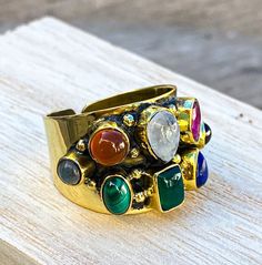 There are 15 assorted rings, each of one is UNIQUE. The ring you need will be pick for you. Brass adjustable ring, with gemstone. 🔮G E M S T O N E S - The stones we use are selected one by one, based on their quality and color. Precious stones are natural, which is why they sometimes have small defects that are considered normal. We assure that each stone has been extracted from Mother Nature with the greatest respect. 💎M A T E R I A L S - Mount:Brass. All our products are hypoallergenic and d Adjustable Multi-stone Moonstone Ring Gift, Adjustable Gold Multi-stone Stackable Rings, Adjustable Gold Stackable Rings With Multi-stone, Adjustable Green Multi-stone Ring, Adjustable Multi-stone Stackable Rings, Adjustable Multi-stone Rings, Multicolor Natural Stone Rings For Anniversary, Gold Bohemian Multi-stone Rings, Bohemian Gold Multi-stone Rings