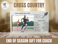 the end of season gift for coach cross country is on display in front of a wooden table