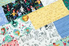 a patchwork quilt with many different colored squares and designs on it, including children's pictures