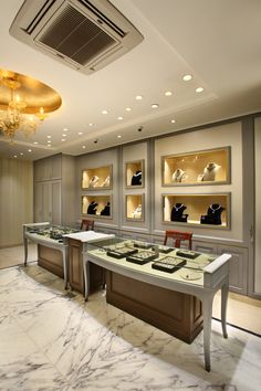 a room filled with lots of shoes on top of tables and chandelier above them