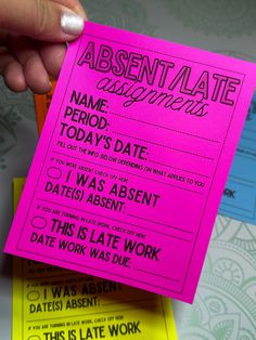 a person holding up a pink paper with the words absentate and an orange pen