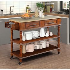 a kitchen island with plates and cups on it in the middle of a wooden floor