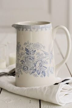 a blue and white coffee mug sitting on top of a table next to a napkin