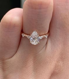 a woman's hand with a diamond ring on top of her finger and an engagement band