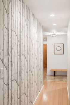 the hallway is decorated with wallpaper and wood flooring