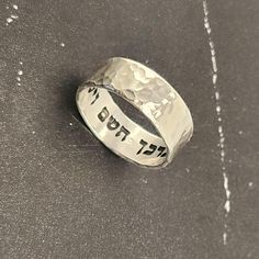 Elevate your style with this Hebrew ring featuring an intricate hammered sterling silver design. Engraved with a secret message from the Bible verse "God bless you and keep you" - "יברכך השם וישמרך" this unique piece exudes elegance and meaning. Perfect for a Jewish wedding band or a meaningful gift. This stunning sterling silver ring is more than just jewelry - it holds the powerful message "This too Shall Pass" from the Song of Solomon. The hammered design adds a touch of uniqueness and charm, making it a meaningful and stylish accessory for any occasion. Embrace tradition with a modern twist with this Hebrew ring crafted from sterling silver. Adorned with a touching Bible verse, "I Am My Beloved," this piece symbolizes love and commitment. Perfect for a Jewish wedding band or as a thoug Hammered Sterling Silver Jewelry For Promise, Spiritual Anniversary Engraved Ring, Wedding Engraved Ring, Stamped 925, Wide Band, Adjustable Engraved Ring With Thick Band For Anniversary, Adjustable Thick Band Engraved Ring For Anniversary, Adjustable Wide Band Engraved Ring, Sterling Silver Engraved Ring For Anniversary, Spiritual Sterling Silver Engraved Ring For Anniversary, Sterling Silver Hammered Engraved Promise Ring