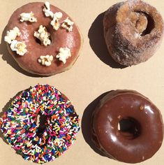 three donuts with sprinkles and popcorn on them