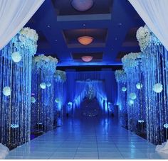 a blue and white wedding decorated with crystal beaded curtains, flowers and candles on the floor