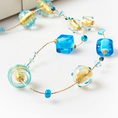 "Length: 88 cm / 34,64 \" Weight: 100 gr / 0,22 lb Classic tradition of this necklace is captured by the unique beads of different shapes: a succession of aquamarine glass squared and rounded beads, covered by precious gold leaf and \"sommerso\" in crystal, alternating with small spheres. The modern touch is given by the small crystals framing each bead, giving them additional light. This necklace, with its bright colours, is perfect for any style and fashion: its light composition makes it the Long Glass Necklace For Party, Long Beaded Chain Necklace As Gift, Glass Large Beads Long Necklace, Modern Colorful Beads Jewelry As Gift, Long Glass Beaded Chain Necklace, Modern Jewelry With Colorful Beads For Gifts, Faceted Beads Lariat Necklace Gift, Elegant Turquoise Glass Beaded Necklace, Modern Colorful Beaded Jewelry For Gifts