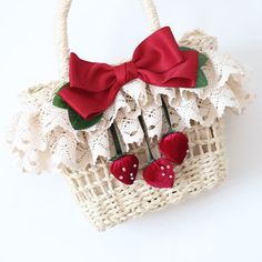 a white basket with red bows and two cherries on it