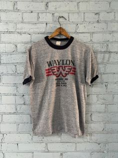 This vintage is a 1982 Waylon Tour T-shirt.  THIS IS THE REAL DEAL AND NOT A REPOP Front: Waylon - A Southern Sun Production - Eustis, Florida - April 18, 1982 Tag: Sportswear 50% Cotton 50% Polyester Made in the USA Size: Large 42-44 (LOOK AT MEASURMENTS) Width (pit to pit): 18.5" Very Good vintage condition, smoke and pet free home Tonak Trading Co. Vintage Crew Neck T-shirt With Letter Print, Vintage T-shirt With Band Logo For Summer, Vintage Fan Merchandise T-shirt With Letter Print, Vintage Band Logo T-shirt For Summer, Vintage Fan Merchandise T-shirt, Vintage Cotton T-shirt For Fan Merchandise, Vintage Crew Neck Fan Merchandise T-shirt, Vintage Crew Neck T-shirt For Fan Merchandise, Vintage Crew Neck T-shirt With Screen Print