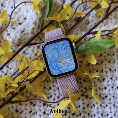 an apple watch sitting on top of a table next to yellow flowers