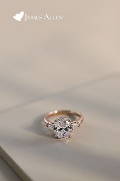 an engagement ring with a single diamond in the center on top of a white surface