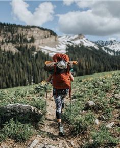 a person with a backpack hiking up a hill