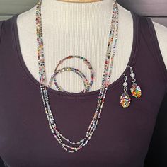 a woman wearing a purple shirt and necklace with multicolored beaded beads on it