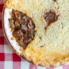 a pie with two pieces cut out on it sitting on a checkered table cloth