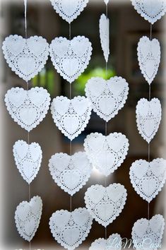 several white heart shaped doily hanging from strings