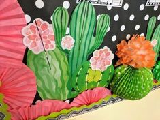 some paper flowers and cactus are on the wall