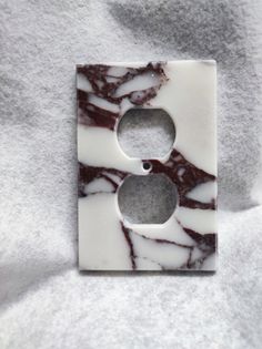 a marble light switch plate cover sitting on top of a white blanket