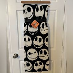 a black and white towel with skulls on it hanging from a door hanger in front of a doorway